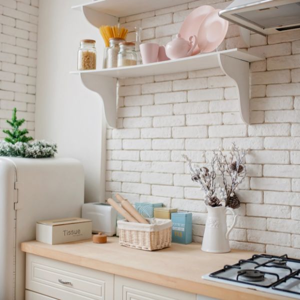 A beautiful white kitchen with bricks wall.